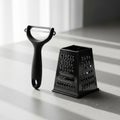 Vegetable peeler and a black box grater. Both have a minimalist Royalty Free Stock Photo
