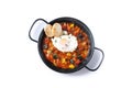 Vegetable pisto manchego with tomatoes, zucchini, peppers, onions,eggplant and egg, served in frying pan isolated on white