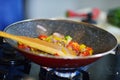 Vegetable ragout in pan, on wooden table on bright background