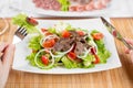 Vegetable salad with beef meat and hands with fork