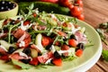 Vegetable salad with Black Forest ham, arugula, cucumber, black olives, red pepper, tomato and Mozzarella Royalty Free Stock Photo