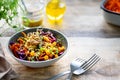 Vegetable salad of fresh red cabbage with carrots, onions, corn, mung seedlings in a plate on wooden background. Selective focus. Royalty Free Stock Photo