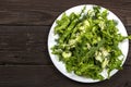 Vegetable salad with fresh vegetables on a wooden table. Salad with green fresh vegetables in a glass bowl. Vegetarian food salad. Royalty Free Stock Photo