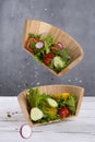 Vegetable salad in levitation. Fresh vegetarian salad in a wooden bowl cut in half.