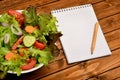 Vegetable salad with notepad Royalty Free Stock Photo