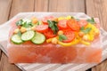 Vegetable salad on pink salt block on stripe napkin Royalty Free Stock Photo