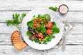 Vegetable salad with spinach, tomatoes, paprika and pumpkin seeds in a plate on a wooden background Royalty Free Stock Photo