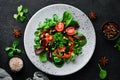 Vegetable salad with spinach, tomatoes, paprika and pumpkin seeds in a plate on a wooden background Top view. Free space for your Royalty Free Stock Photo