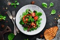 Vegetable salad with spinach, tomatoes, paprika and pumpkin seeds in a plate on a wooden background Top view. Free space for your Royalty Free Stock Photo