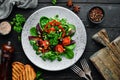 Vegetable salad with spinach, tomatoes, paprika and pumpkin seeds in a plate on a wooden background Top view. Royalty Free Stock Photo