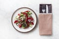 Vegetable salad with tomato and cucumber, red onion, hot peppers, walnuts, a traditional Georgian dish, on a marble table Royalty Free Stock Photo