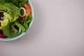 Vegetable salad. Vegan, vegetarian healthy, diet nutrient meal in green bowl on gray paper background. Royalty Free Stock Photo