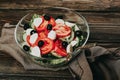 Vegetable salad on a wooden background. Lettuce, tomato, cucumber, olives, mozzarella and olive oil. Wholesome healthy Royalty Free Stock Photo