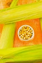 Vegetable set corn complex ear and peeled grains in a white bowl on a bright background Royalty Free Stock Photo