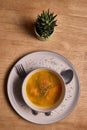 Vegetable soup or broth with pumpkin and chickpeas in a bowl. fine spreading herbs. solid wood background. Healthy, vegan and diet