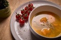 Vegetable soup or broth with pumpkin and chickpeas in a bowl. fine spreading herbs. solid wood background. Healthy, vegan and diet