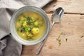 Vegetable soup with brussels sprout, leek and potato in a bowl, spoon and napkin on a rustic wooden table, high angle view from Royalty Free Stock Photo