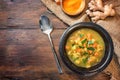 Vegetable soup with curry, turmeric and ginger in a dark bowl on a rustic wooden table, copy space, high angle view from above Royalty Free Stock Photo
