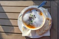 Vegetable soup with fresh sprouts and foam garnish as appetizer at an outdoor menu on a wooden garden table, copy space, high Royalty Free Stock Photo