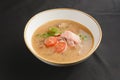 Vegetable soup with salmon in white bowl over black background. Dinner concept, healthy hot soup Royalty Free Stock Photo