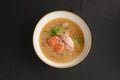 Vegetable soup with salmon in white bowl over black background. Dinner concept, healthy hot soup Royalty Free Stock Photo