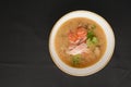 Vegetable soup with salmon in white bowl over black background. Dinner concept, healthy hot soup. Royalty Free Stock Photo