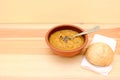 Vegetable soup served with seasoning and bread roll