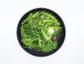 Vegetable spinach with shallots placed in a black bowl against a white background Royalty Free Stock Photo