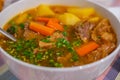 Vegetable stew with meat and potatoes served in a plate on a kitchen table at home. Beef stew farm-style Royalty Free Stock Photo