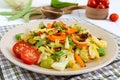 Vegetable stew - a mixture of baked cabbage, green beans, onions, carrots, cherry tomatoes, sweet pepper on a plate Royalty Free Stock Photo
