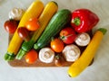 Vegetable still life. Vegetables on a cutting board on the kitchen table. Zucchini, tomatoes, champignons, peppers. Red, yellow, o