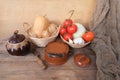 Vegetable stocks are laid out on wooden shelf, ripe red tomatoes, head of cabbage in basket, garlic, pumpkin, onions, old dishes,