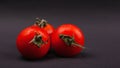 Vegetable, three cherry tomatoes on a dark background close-up Royalty Free Stock Photo