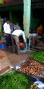 Vegetable vendor measuring goods weight at agriculture produce market