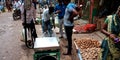 Vegetable vendor measuring goods weight on machine t farmers market