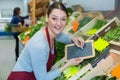 Vegetable vendor writing info on blackboard