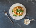 Vegetable waffles from young zucchini with cheese and basil on a white plateA pile of squash waffles, a white sauce bowl