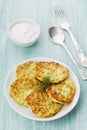 Vegetable zucchini cabbage pancakes or fritters with sour cream on wooden table Royalty Free Stock Photo