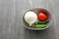 Variety of fresh vegetables in basket and chopping board ready to cook a Mexican sauce: onion, tomato, green chilies Royalty Free Stock Photo