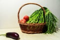 Vegetables in basket on table, tomatoes, garlic seedlings, eggplant , healthy eating concept