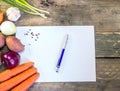 Vegetables with blank paper on wooden table . Writing a prescri