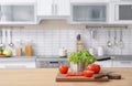 Vegetables and blurred view of kitchen interior on background