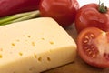 Vegetables and cheese on cutting board, on white background Royalty Free Stock Photo