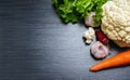 Vegetables close-up. Cauliflower, garlics, carrot, lettuce and red pepper on a wooden table. Top v