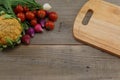 Vegetables and cutting board on a wooden background Royalty Free Stock Photo