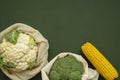 Vegetables in eco bag on green surface with a copy space. Pepper, tomato, corn, cucumber, broccoli, cauliflower in Royalty Free Stock Photo