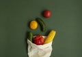 Vegetables in eco bag on green surface. Pepper, tomato, corn, cucumber, broccoli, cauliflower in reusable shopping eco Royalty Free Stock Photo