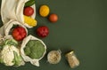 Vegetables in eco bag and nuts in a glass jar on green surface. Pepper, tomato, corn, cucumber, broccoli, cauliflower in Royalty Free Stock Photo