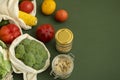 Vegetables in eco bag and nuts in a glass jar on green surface. Pepper, tomato, corn, cucumber, broccoli, cauliflower in Royalty Free Stock Photo