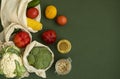 Vegetables in eco bag and nuts in a glass jar on green surface. Pepper, tomato, corn, cucumber, broccoli, cauliflower in Royalty Free Stock Photo